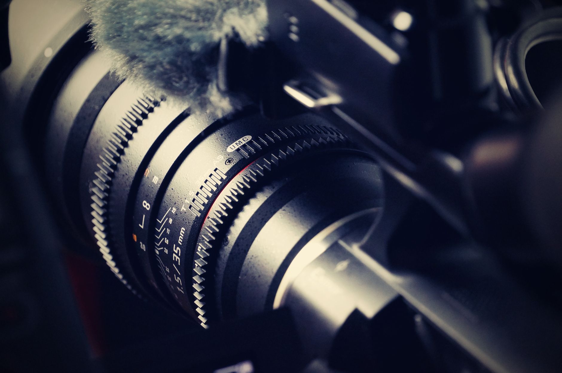 Close-up of a professional camera lens and video production gear